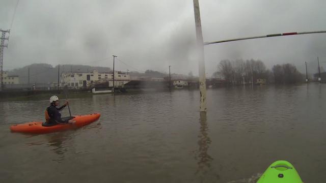 Deux kayakistes se baladent sur un terrain de rugby dans le Pays basque.